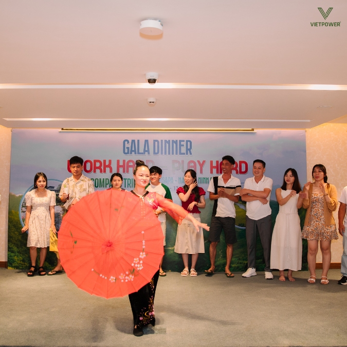 Dưới ánh đèn, nàng vũ công thướt tha xoay chiếc ô đỏ thắm, cuốn hút mọi ánh nhìn