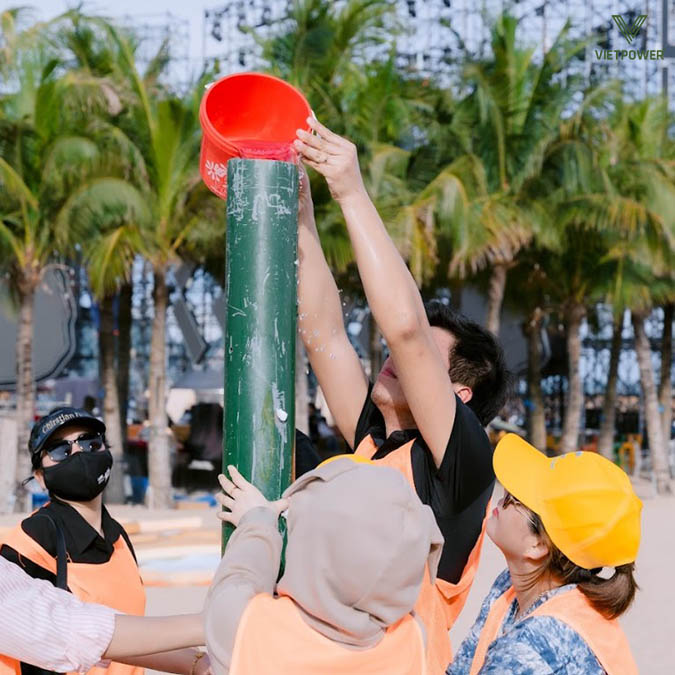 Thành viên chuyền từng ca nước từ biển về thùng chứa của đội mình Thành viên chuyền từng ca nước từ biển về thùng chứa của đội mình