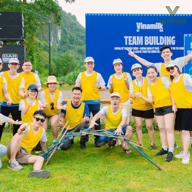 đội áo vàng vinamilk chụp hình với mô hình đã hoàn thiện trong trò chơi xây cầu vinamilk team building 2024
