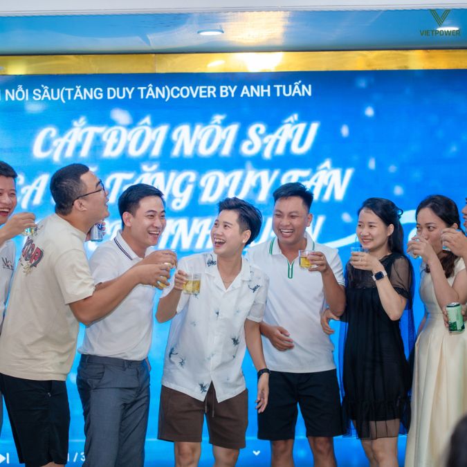Một nhóm thành viên cụng ly và ăn mừng trên sân khấu