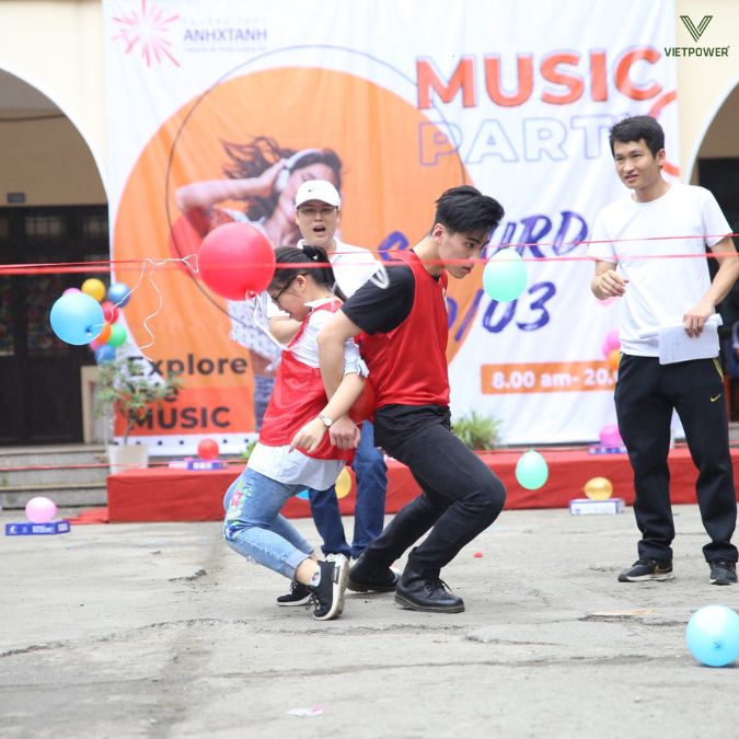 Một cặp nam nữ dùng lưng để giữ quả bóng không rơi