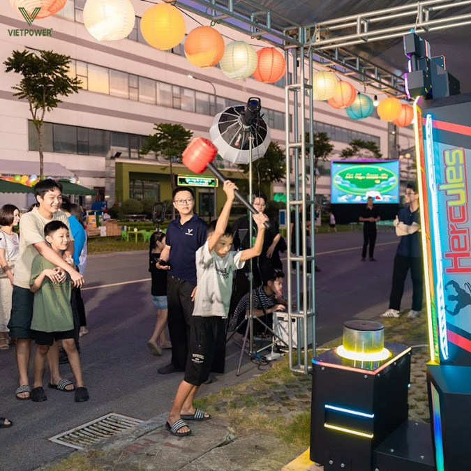 Các em nhỏ cũng thử sức với máy đập búa để thử thách sức mạnh